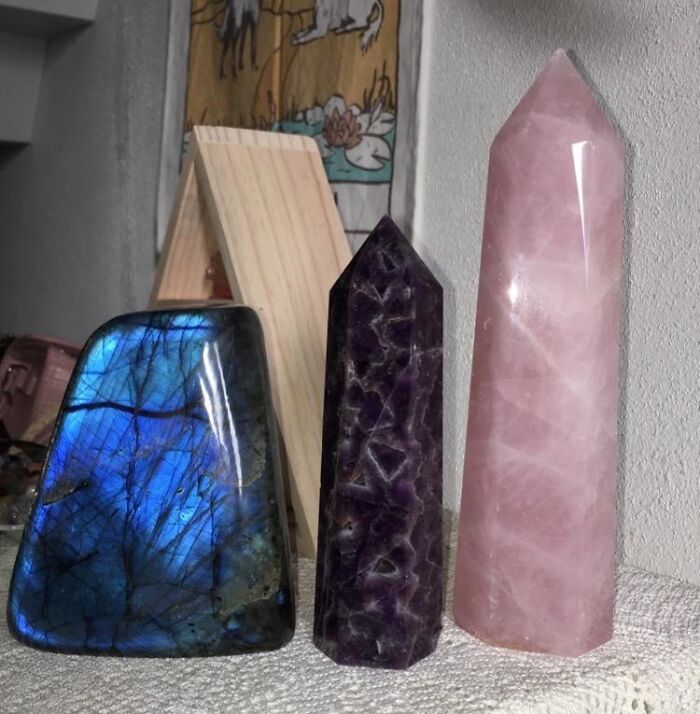 Three colorful polished gemstone towers in blue, purple, and pink on a shelf from thrift store finds