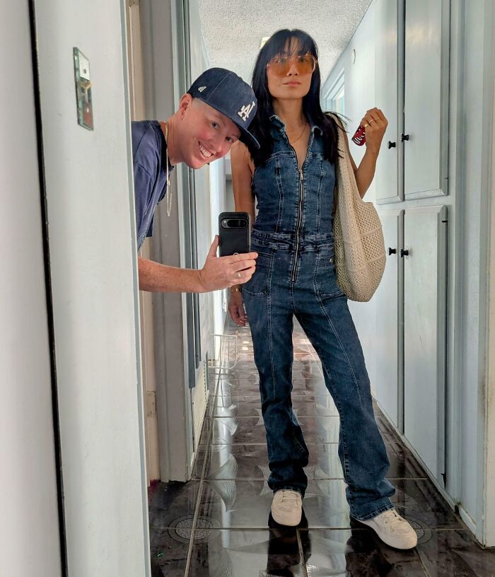 A woman wearing a denim jumpsuit that she bought as one of her thrift store finds