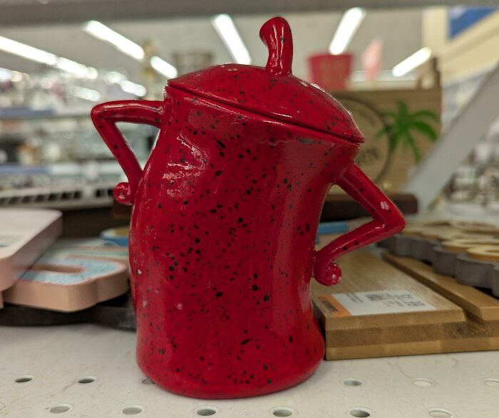 A quirky red ceramic jar with handles, discovered as one of many unique thrift store finds.