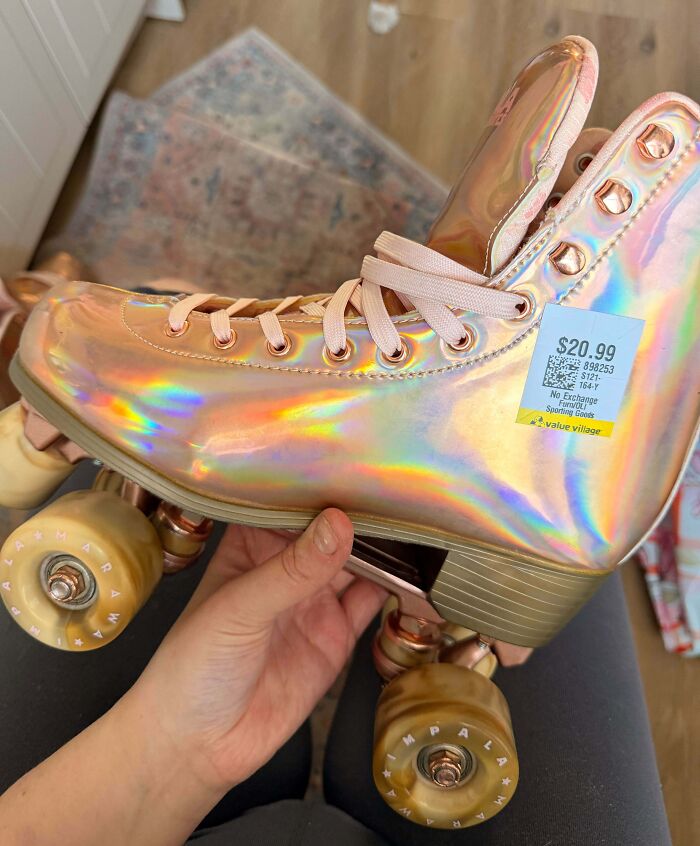 A hand holding a holographic roller skate with a thrift store price tag, showcasing unique secondhand finds.