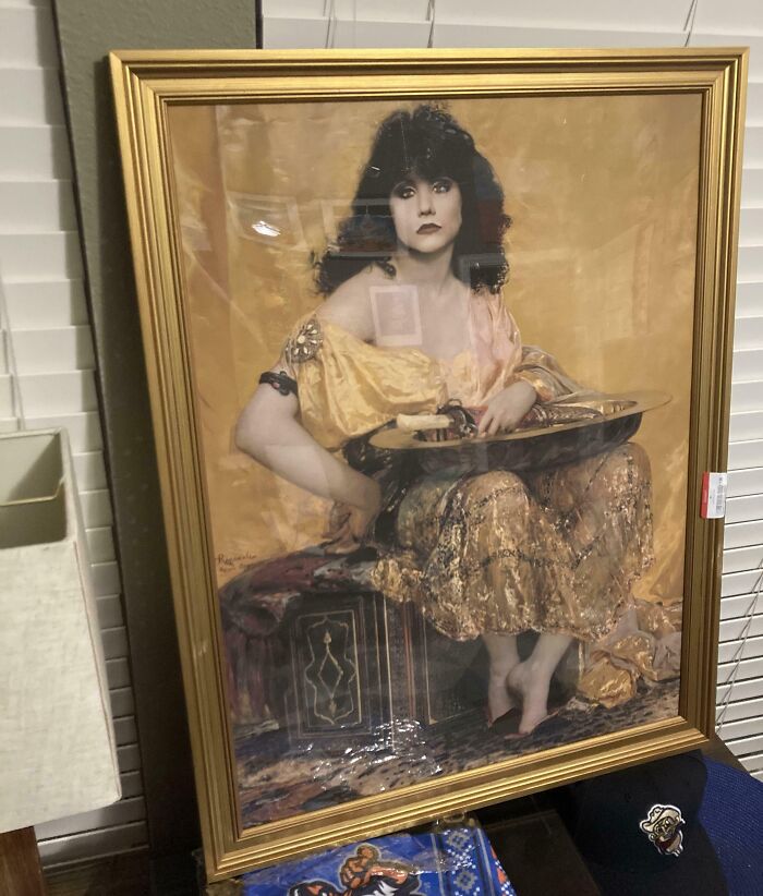 A gold-framed vintage painting found as one of the thrift store finds, depicting a woman in classical attire