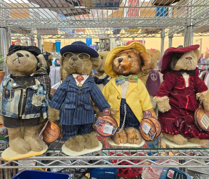 Collectible plush teddy bears dressed in unique vintage outfits displayed on a thrift store shelf