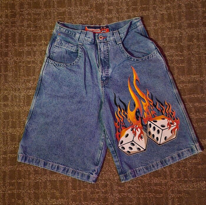 A pair of vintage denim shorts with a flaming dice graphic, unique thrift store finds.