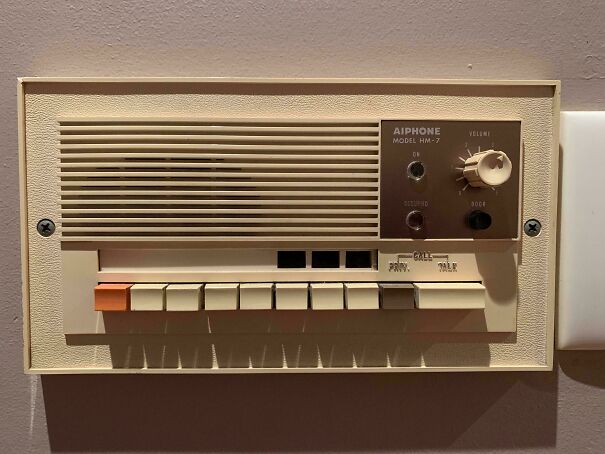 A retro cream-colored wall-mounted intercom system with buttons, demonstrating vintage tech finds