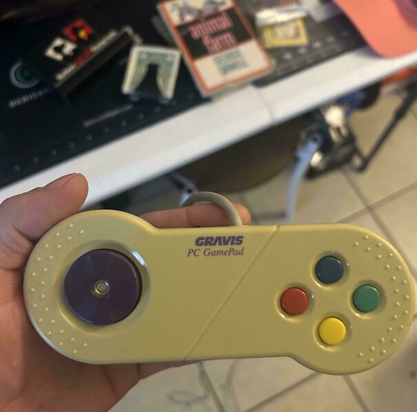 A person holding a classic Gravis PC GamePad representing nostalgic vintage tech accessories