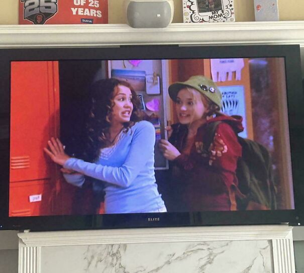 A wide flat-screen TV displaying a scene from Hannah Montana representing vintage tech
