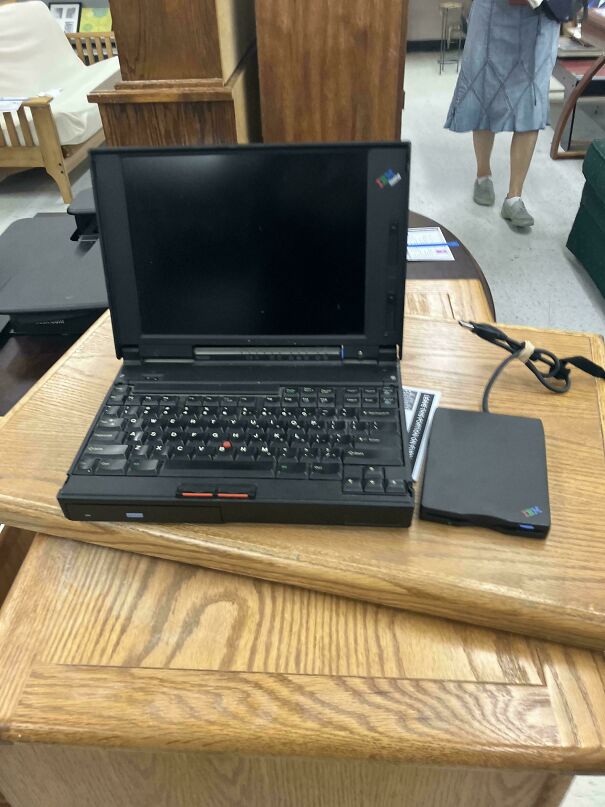 A classic chunky black IBM ThinkPad laptop open on a table, a prime example of vintage tech finds