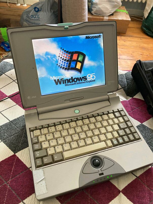 A vintage tech laptop booted up with the classic Microsoft Windows 95 operating system on its screen
