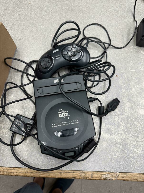 A Sega CDX multimedia console with controller representing vintage tech finds