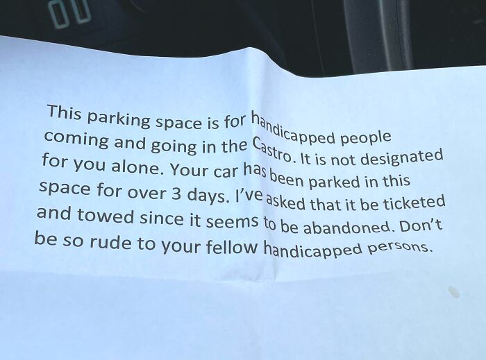 A passive-aggressive printed note left on a car showing entitled Karen behavior over a parking spot.