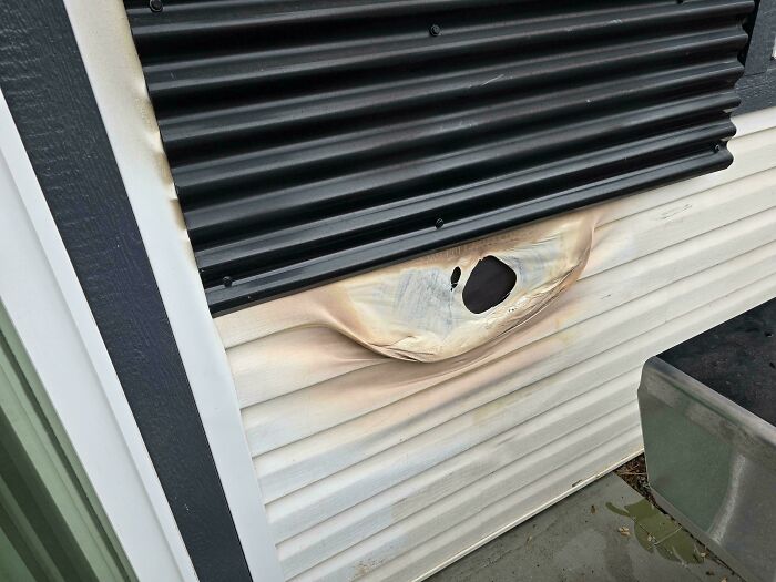 Melted siding below a black corrugated metal panel highlighting poor design and questionable decisions.