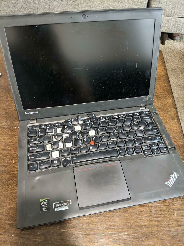 A Lenovo ThinkPad laptop with broken and misplaced keyboard keys demonstrating highly questionable decisions.