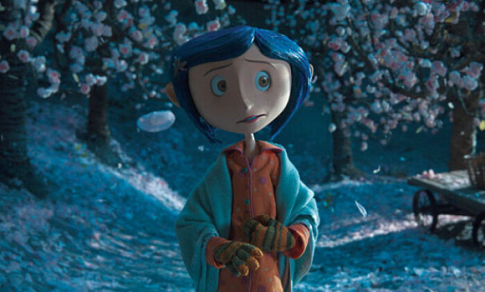 A stop-motion puppet of Coraline in an orchard, illustrating miniature movie props.