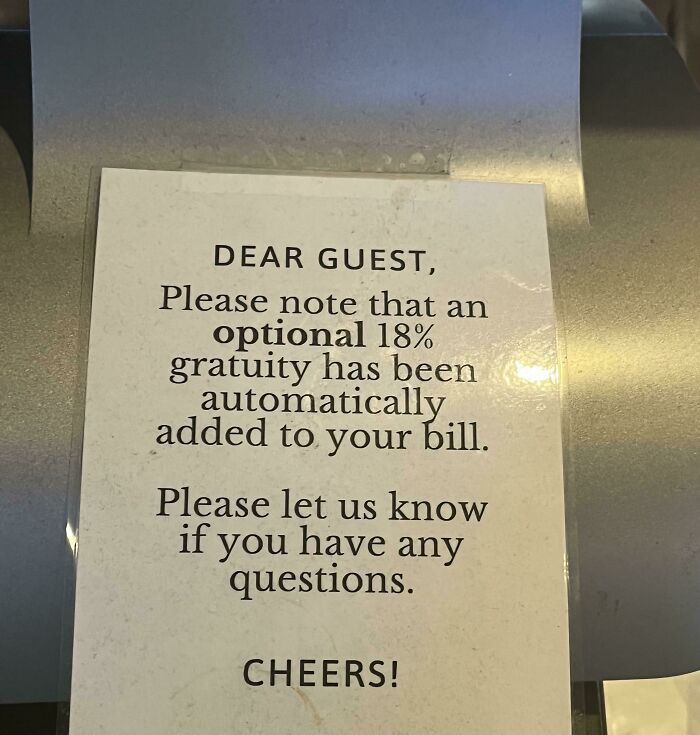 A restaurant sign stating an optional 18% gratuity is automatically added, showing questionable decisions.