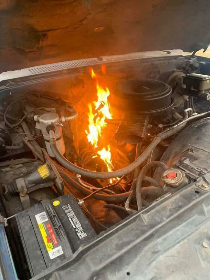 A car engine caught on fire under the hood highlighting questionable maintenance decisions