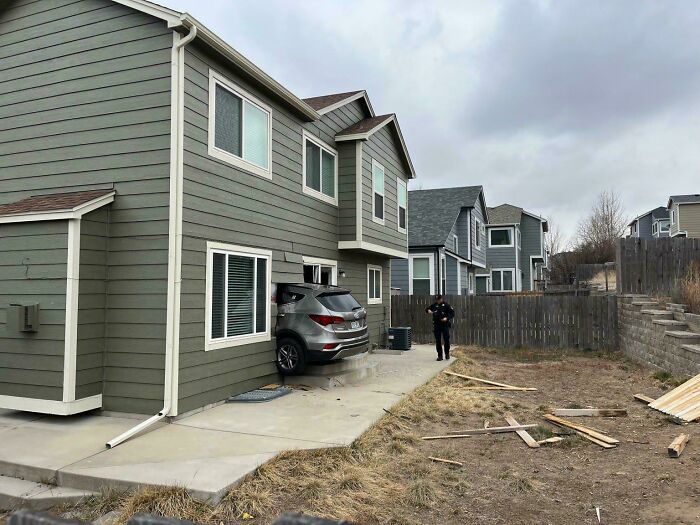 A silver SUV crashed into the side of a house, showcasing a highly questionable driving decision