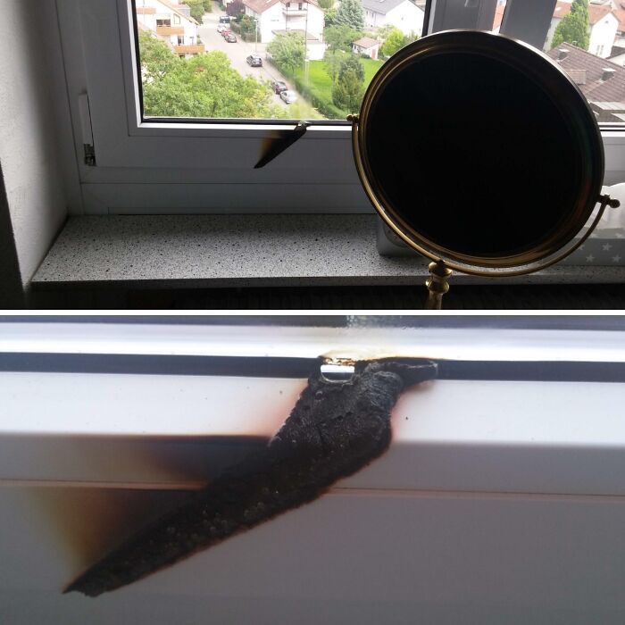 A mirror reflecting sunlight that burned a black scorch mark into a white window sill, showing questionable decisions.