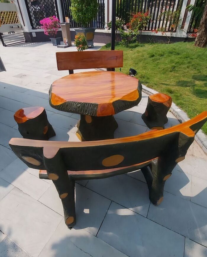 Rustic outdoor wooden table and bench set on a patio, showcasing natural wooden creations.