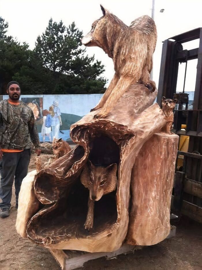 Clever wooden creations featuring a large detailed carving of wolves emerging from a tree trunk log