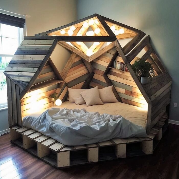 A cozy dome-shaped bed built from geometric wood panels and warm lighting as one of many clever wooden creations