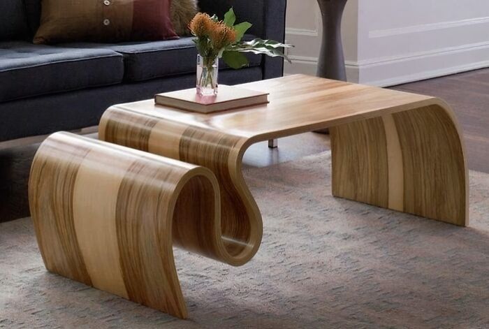 A modern coffee table with curved wooden creations in a living room setup