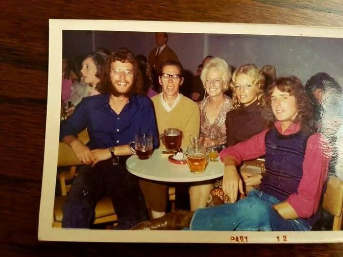 Group of friends enjoying drinks at a 70s bar or pub