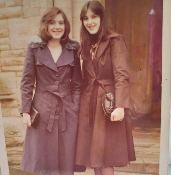 Vintage 1970s photo of two women wearing long coats posing outdoors