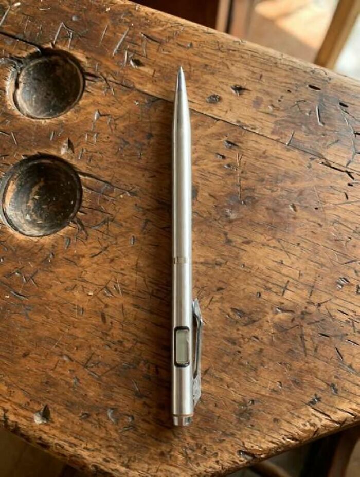 Vintage classic pen with digital calculator on scratched wooden desk