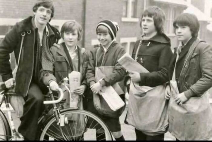 Vintage 1970s photo of young newspaper delivery boys with a bicycle