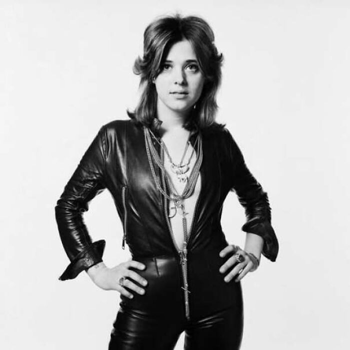 Suzi Quatro posing in a black leather jumpsuit in iconic black and white 70s photos.