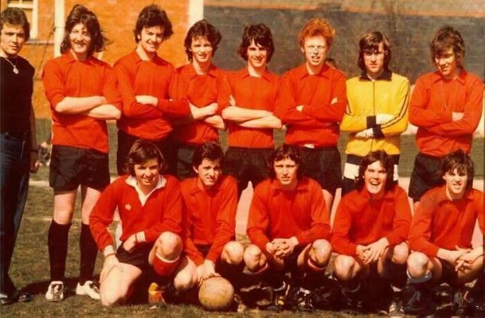 1970s group photo of soccer team in red uniforms posing on field