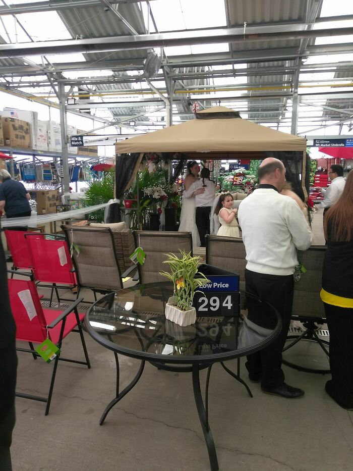 Questionable wedding moments as a couple gets married under a patio canopy inside a retail store.