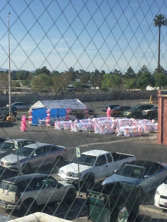 A parking lot set up with tables and pink balloons for questionable wedding moments.