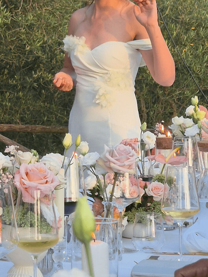 A close-up of a bride in her wedding dress at a dinner table representing questionable wedding moments