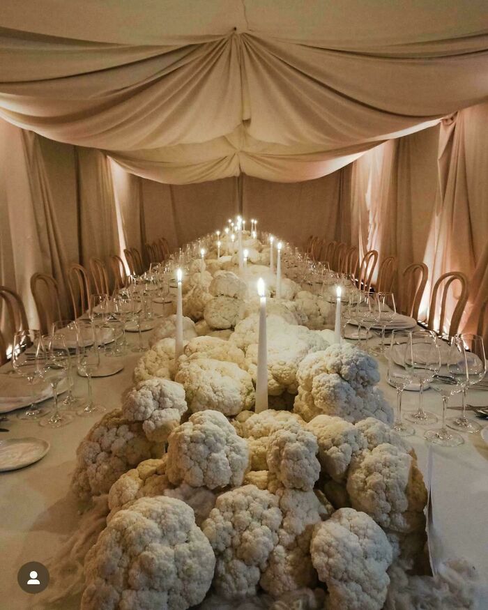 A questionable wedding moments table centerpiece made entirely of raw cauliflower heads and candles