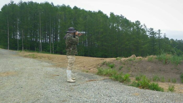 A man in green jacket blending with forest background, representing accidental camouflage