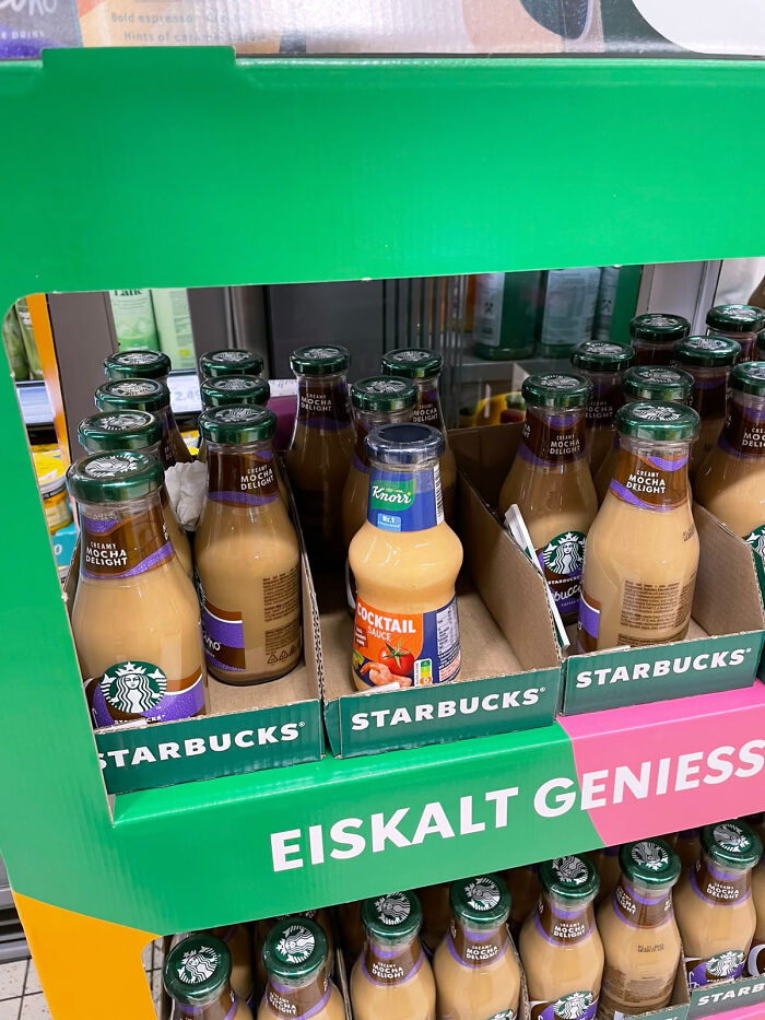 A single orange sauce bottle misplaced in Starbucks mocha shelf, showing accidental camouflage