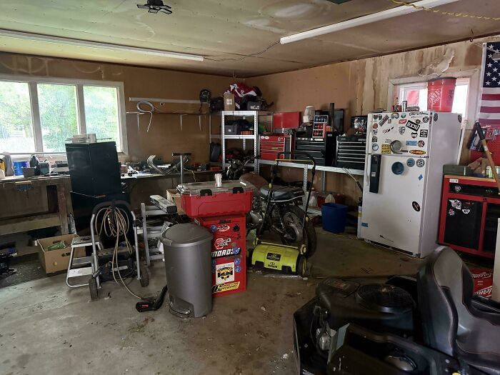 An old motorcycle hidden amongst cluttered garage shelves, an example of accidental camouflage
