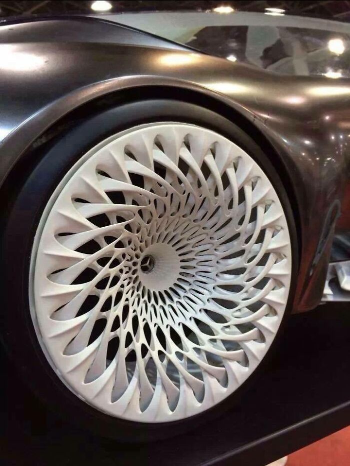 Close-up of an intricate, futuristic car wheel rim created using a 3D printer.