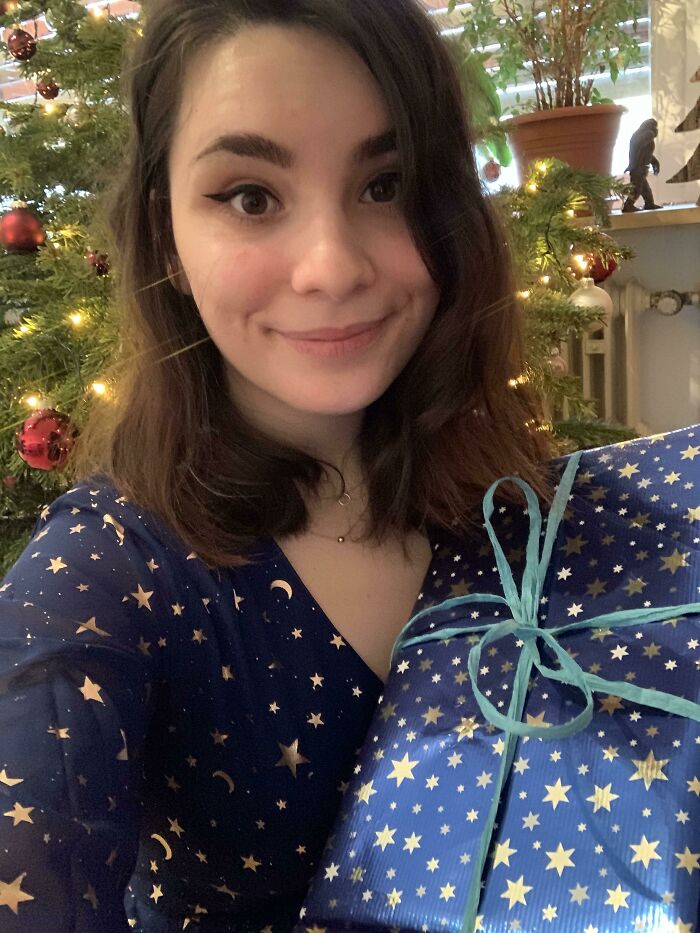 A woman wearing a star-patterned dress matching a gift wrapping paper, showing accidental camouflage