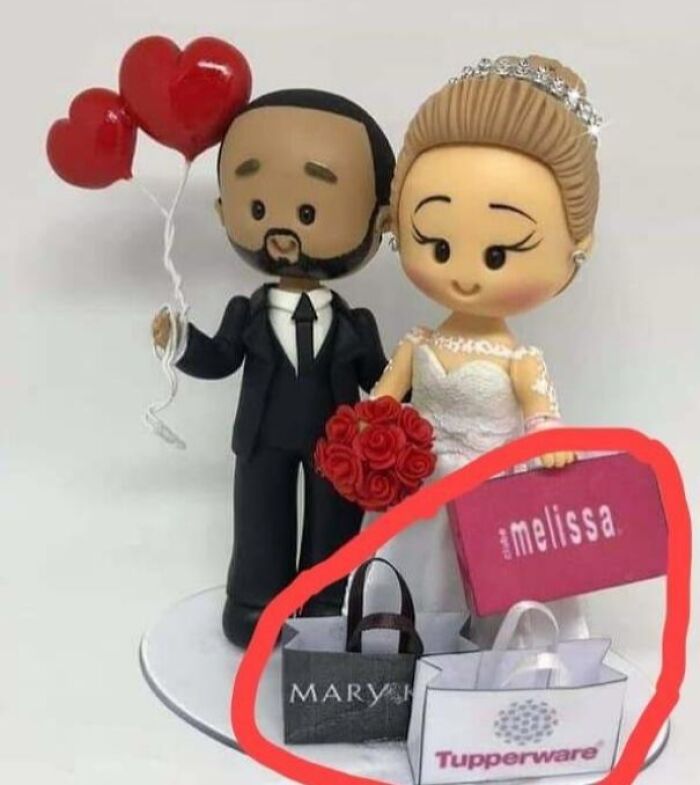 A wedding cake topper doll surrounded by miniature shopping bags, a questionable wedding moment