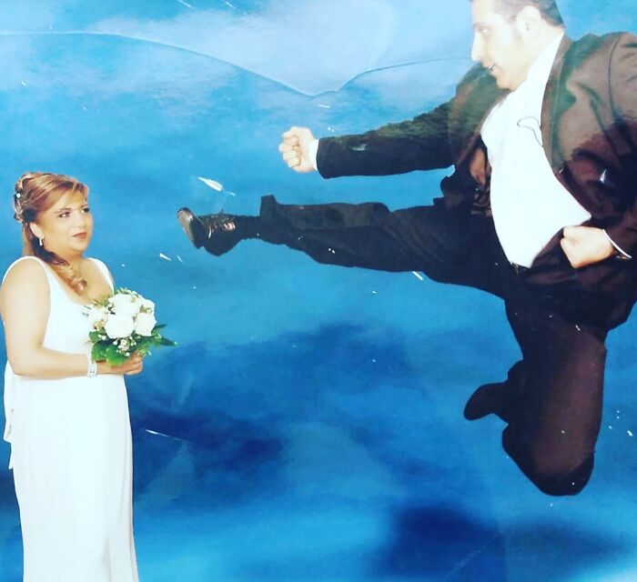 A questionable wedding photo of a groom mid-air doing a karate kick towards his bride