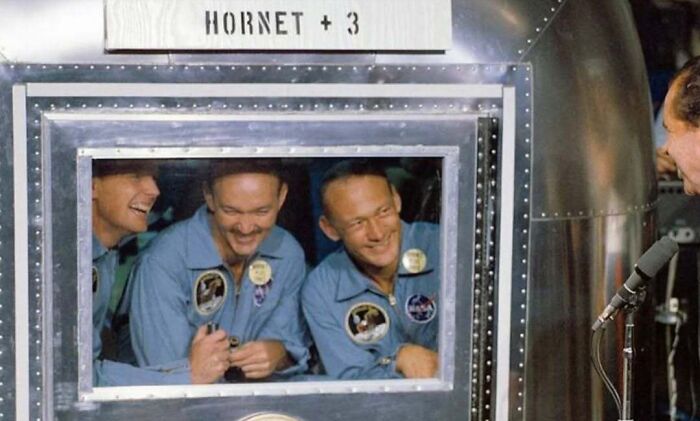 Apollo astronauts inside spacecraft window, iconic space exploration history