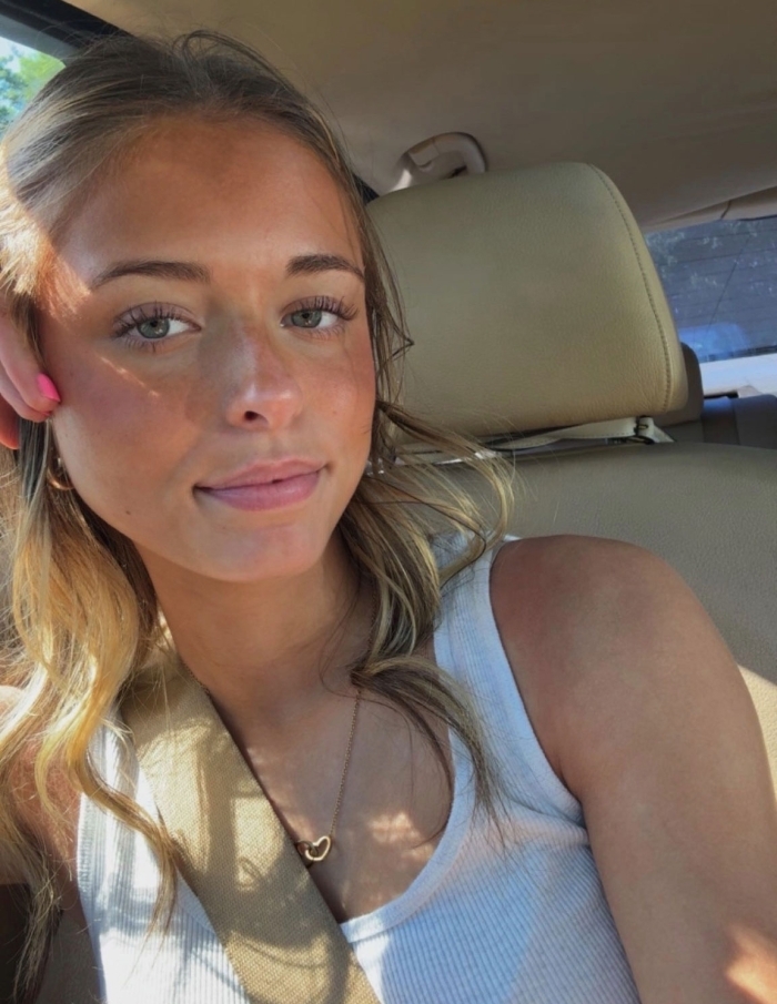 A sunny car selfie of the viral Beautiful Mid meme subject wearing a white tank top A sunny car selfie of the viral Beautiful Mid meme subject wearing a white tank top