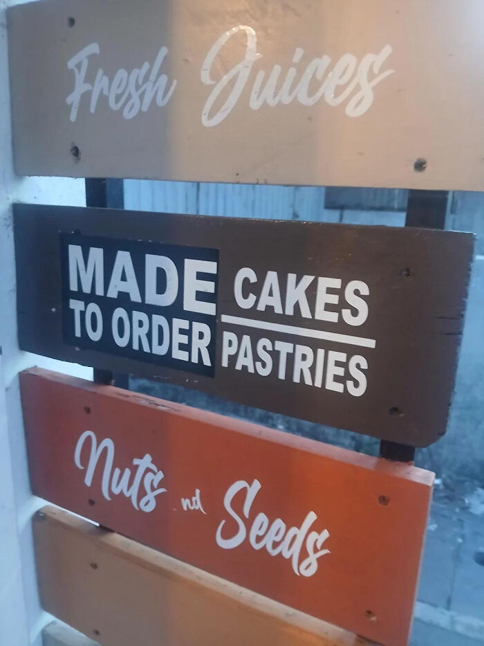A poorly aligned wooden menu, perfect example of badly designed signs.
