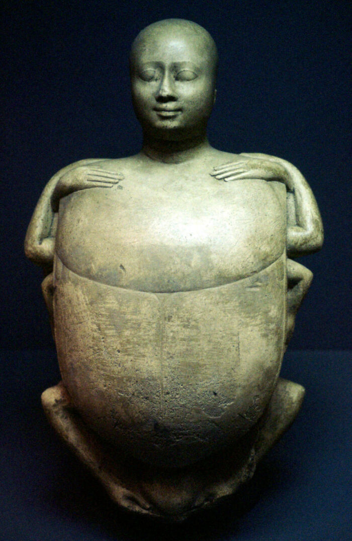 Creepy ancient stone sculpture showing a human figure with extra limbs