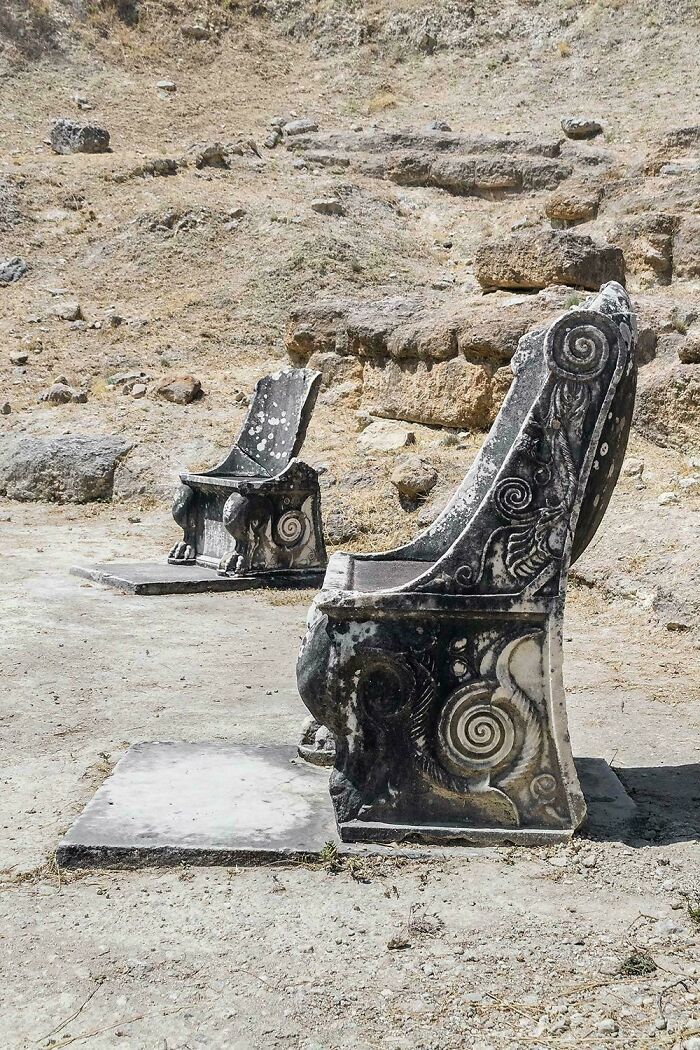 Ancient stone chairs with intricate spiral carvings archaeological artifact