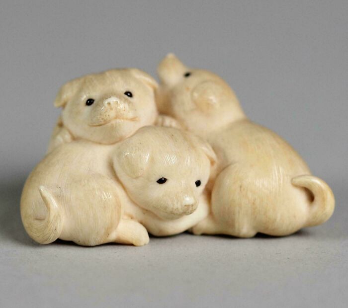 Intricately carved ivory figurine of three small puppies