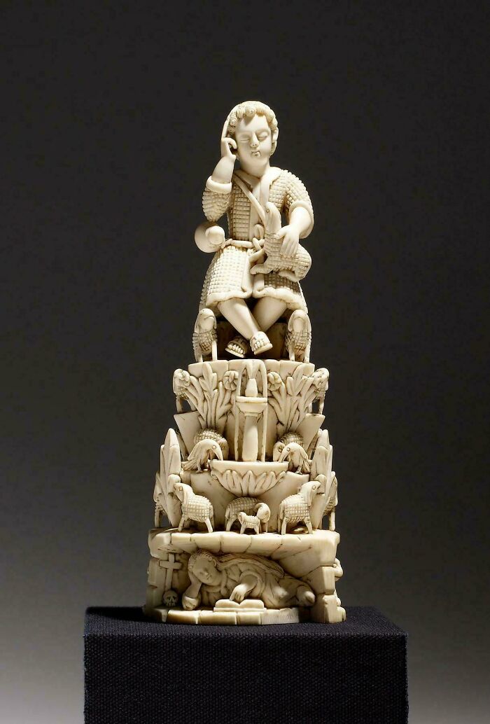 Intricately carved ivory statue featuring a seated figure and animals artifact