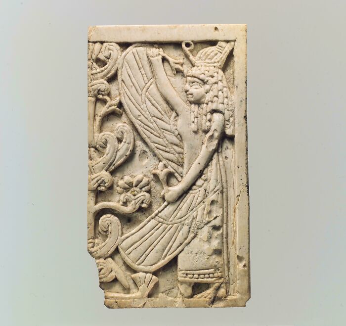 Carved ivory relief of an ancient winged figure and floral motifs